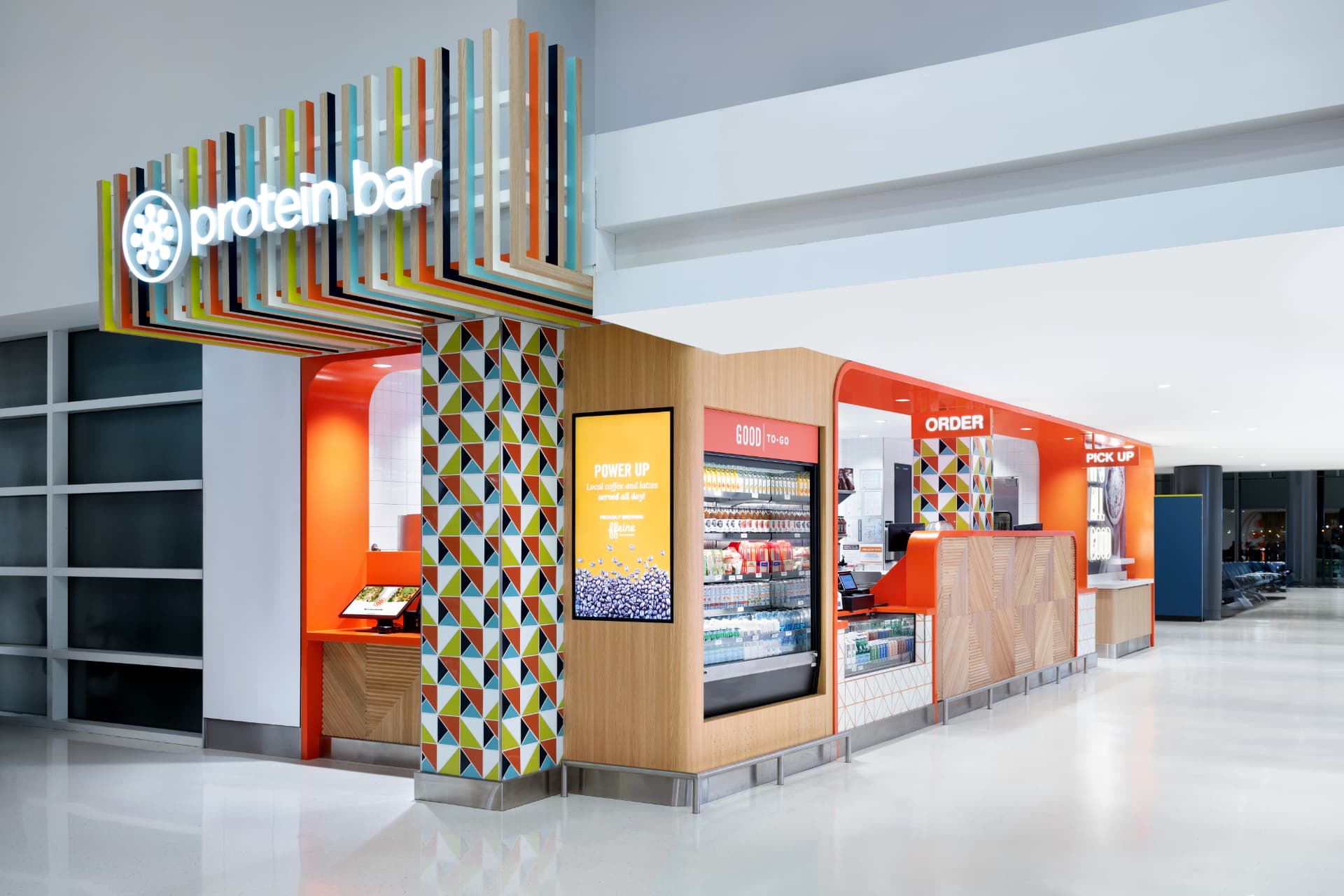 Protein Bar & Kitchen location with geometric tile column and grab-and-go cooler at O'Hare Airport