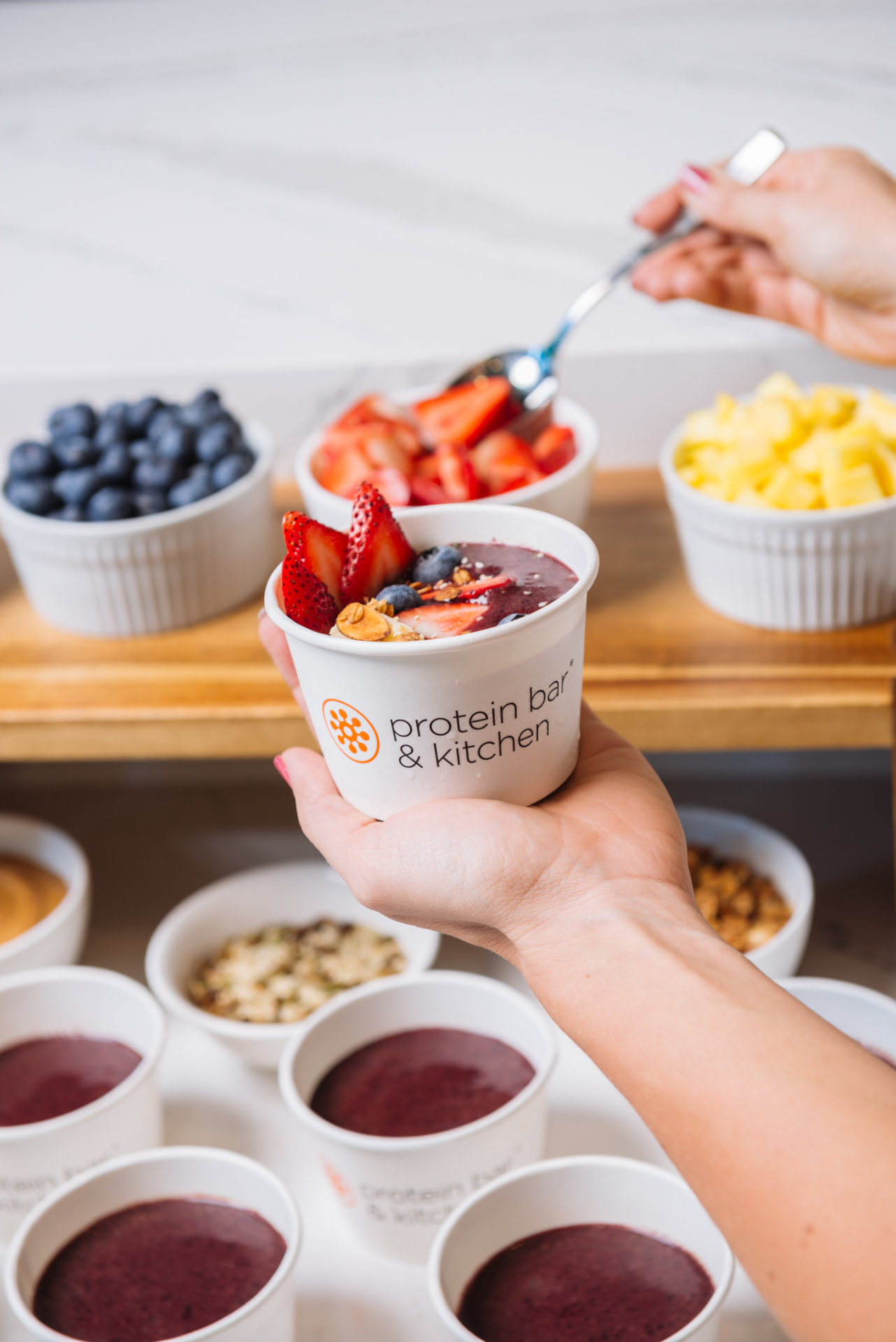 A Protein Bar & Kitchen açaí bowl topped with strawberries and blueberries
